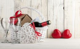 jakie wino na prezent wybrać? biały kosz prezentowy z winem i dwiema lapkami